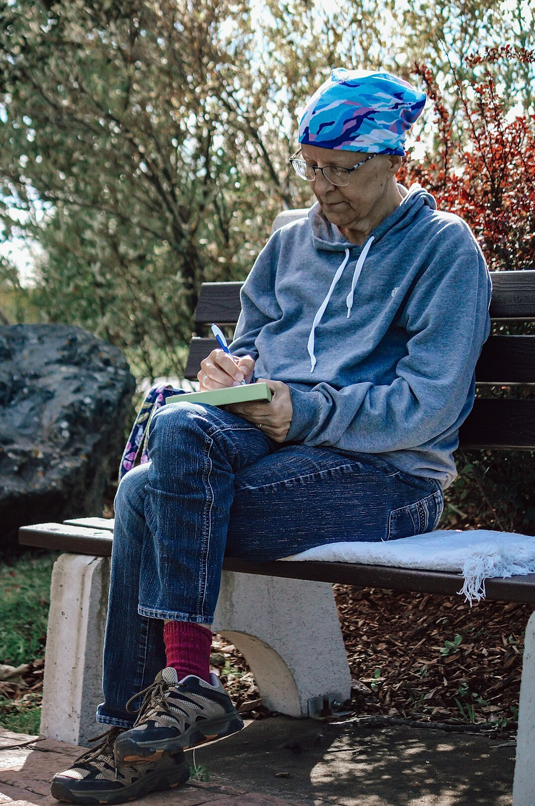person writing in journal outdoors