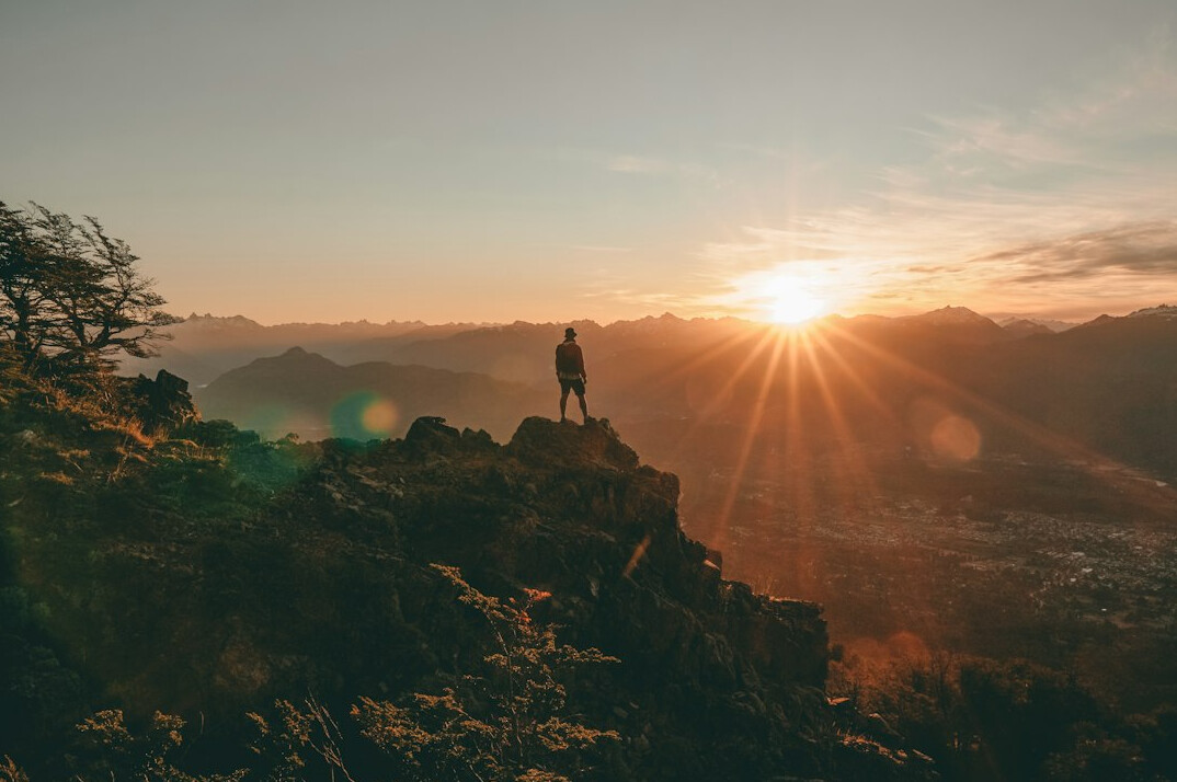 person achieving goal on mountain